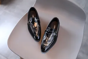 Gros plan de chaussures enfants en cuir verni léopard noir avec boucle métallique