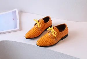 Détail de chaussures Oxford orange pour garçon avec texture croco et lacets