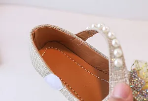 Detalle de merceditas con purpurina oro champán para niñas con tira de perlas y costura