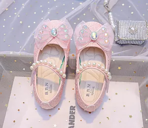 Détail de paillettes roses, nœud en résille et perles sur chaussure de princesse fille