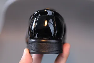 Détail macro du talon en cuir verni noir brillant avec semelle antidérapante du soulier