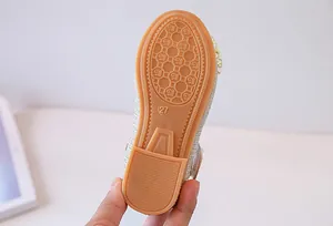 Primer plano de la suela antideslizante talla 27 en zapatos de princesa dorados brillantes