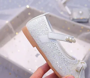 Detail of silver glitter Mary Jane shoes with pearls and bow for girls parties