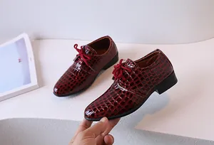 Détails de chaussures en cuir bordeaux pour enfants avec motif crocodile gaufré