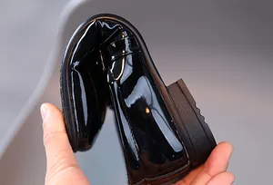 Détail montrant la semelle souple et pliable de ces chaussures en cuir verni noir