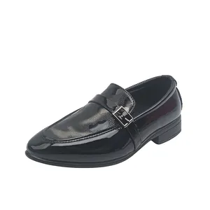 Détail de chaussures en cuir verni noir pour garçons avec boucle et texture grise