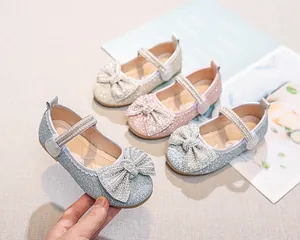 Dettaglio delle scarpe da principessa per bambina con strass luccicanti e fiocco