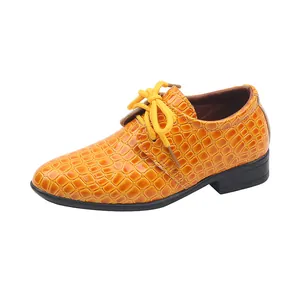 Détail de chaussure habillée orange pour garçon avec finition motif crocodile chic
