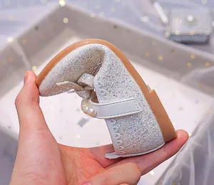 Flexible rubber sole of silver sequin Mary Jane shoes showing extreme bendability