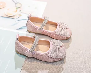 Dettaglio di scarpe Mary Jane rosa con paillettes, fiocco di perle e strass per bambina