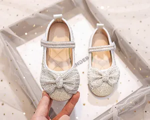 Dettaglio scarpe da principessa bianche per bambina con fiocco di strass e perle