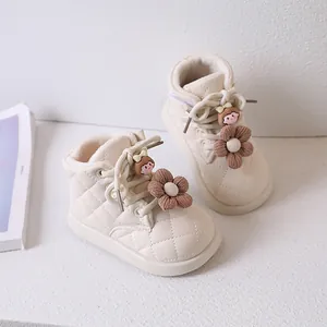 Dettaglio degli stivaletti trapuntati beige per bambine con fiore e calda fodera in pile