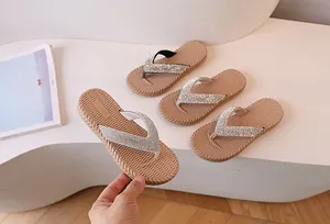 Detail of beige flip flops with silver rhinestones on a slip-resistant woven textured sole