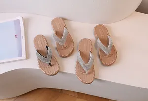 Close-up of sparkling rhinestone straps and woven texture soles on flip-flop sandals