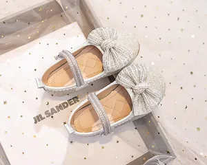 Dettaglio di scarpe Mary Jane argento con fiocco di strass e cinturino di perle