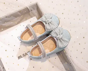 Dettaglio di scarpe da principessa per bambina con fiocco di strass e perline