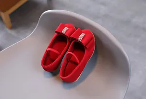 Détail de ballerines rouges Mary Jane pour filles avec gros nœud en strass et fini suède