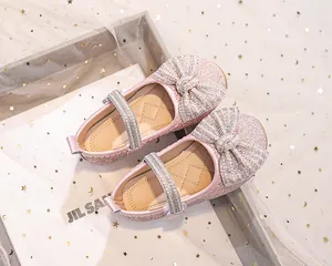 Dettaglio di scarpa da principessa rosa con paillettes, fiocco di strass e perle