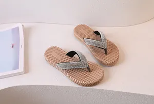 Top view of beige flip flops featuring silver rhinestones and woven straw texture sole