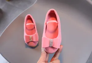 Gros plan détaillé de ballerines roses pour filles avec nœud en strass et texture daim
