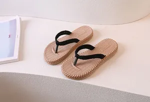 Detail of soft-sole flip flops featuring beige woven texture and black straps