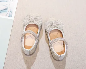 Dettaglio scarpe da principessa glitterate con grande fiocco di strass e cinturini di cristallo