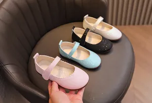 Détail de chaussures Mary Jane pailletées pour filles avec bords festonnés et velcro