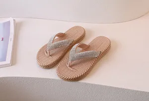 Close-up of sparkling rhinestone straps and woven texture sole on pink flip-flops