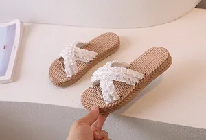 Detail of cross-strap slippers with ruffle texture and woven non-slip sole in white