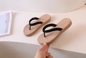 Detail view of beige woven texture flip flops with flexible sole and black strap