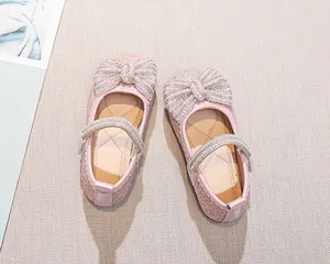 Dettaglio scarpe Mary Jane rosa glitterate con fiocco di strass e perle cinturino