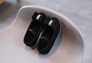 Détail de babies noires pour filles avec nœud en strass brillant et bride élastique