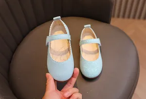Gros plan de ballerines Mary Jane pailletées bleu clair avec bordure ondulée