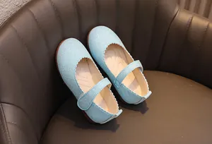 Détail de chaussures Mary Jane à paillettes bleu clair avec bords festonnés et velcro