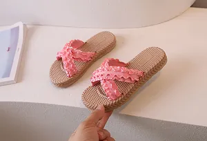 Detailed view of pink ruffled cross strap design on stylish flat summer sandals