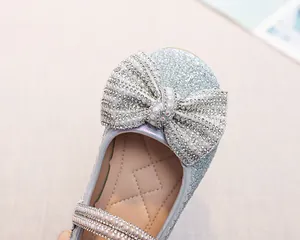 Dettaglio scarpa Mary Jane blu scintillante con doppio fiocco e perle eleganti