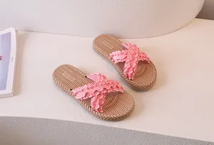 Detail view of pink ruffled cross straps and woven texture sole of the summer slides