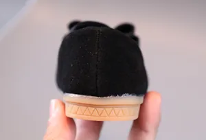Détails de la semelle en gomme antidérapante et de la finition noire de la chaussure fille
