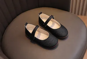 Détail de ballerines noires à paillettes pour filles avec bord ondulé et bride velcro