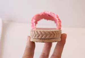 Detailed view of pink ruffled fabric slippers with woven texture and non-slip sole