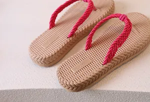 Detail of beige woven texture sole and pink braided straps on casual flip flops