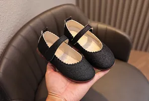 Détail de chaussures Mary Jane noires à paillettes pour filles avec bords festonnés