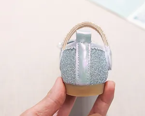 Dettaglio di scarpe da principessa per bambina con strass luccicanti e tallone viola colorato