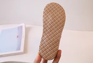 Detailed macro shot of the non-slip honeycomb rubber sole on khaki flip-flops