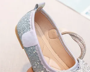 Dettaglio scarpe da principessa per bambina con paillettes lucide e cinturino di perle