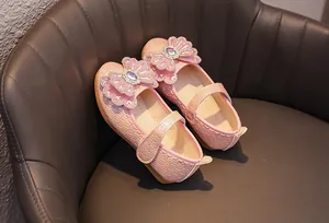 Detail of pink girls' Mary Jane shoe with pearl texture and jewel-encrusted bow