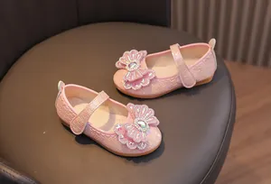 Detail of pink Mary Jane shoes for girls featuring a rhinestone bow and woven texture