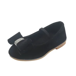 Detail of girls black suede Mary Janes featuring a rhinestone bow and elastic strap