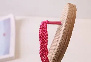 Detail of pink woven flip-flop strap with protective tubing and anti-slip textured sole