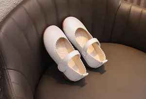 Détail de chaussures Mary Jane argentées scintillantes avec bords festonnés